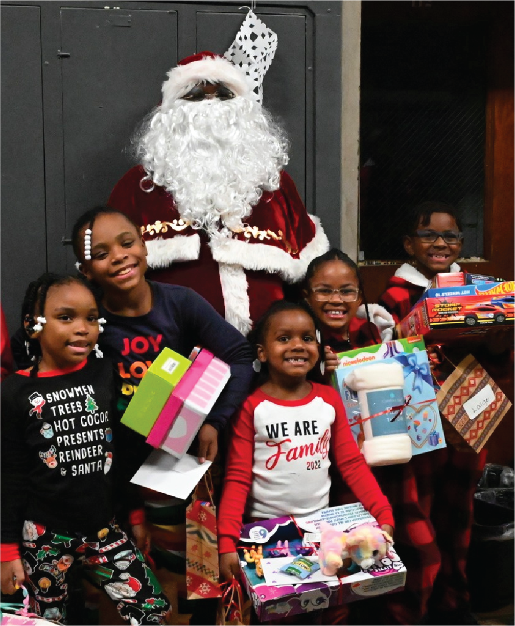 Children gathered around santa claus at a L.I.T. Friday Event